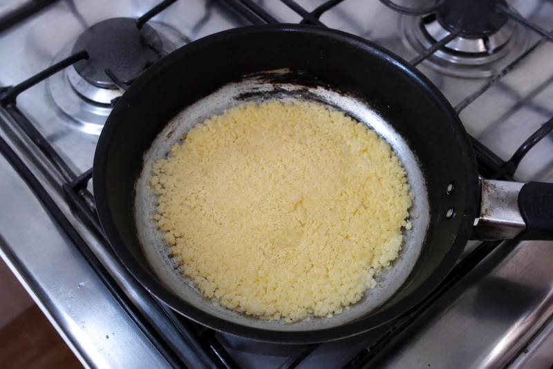 Mbejú cocinándose en una sartén sobre cocina a gas